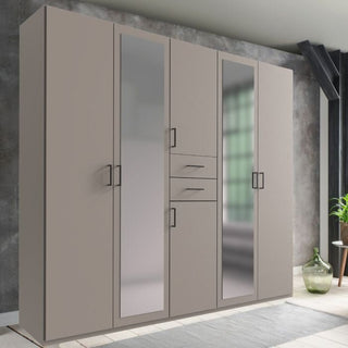 The CHOICEWARDROBE Dorian 5 Door Mirrored Wardrobe in matte grey features ample modern storage, mirrored panels, and a sleek 225cm design—perfect for placing against a gray wall with a rug and glass vase nearby.