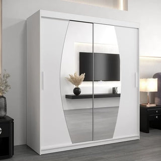 The CHOICEWARDROBE Eden 2 Door Mirrored Sliding Wardrobe (180cm, White Finish) stands in a modern bedroom, its curved mirrors reflecting a wall-mounted TV, floating shelf with vase, and part of a lit bedside table.
