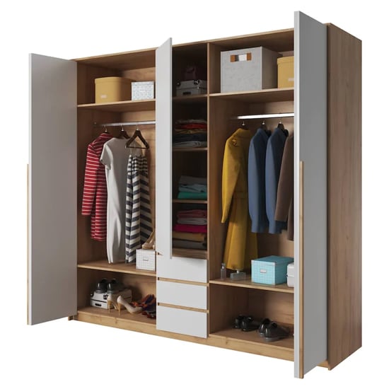 Elara 3-door hinged wardrobe in Golden Oak and White, open with visible shelves, hanging rails and drawers.