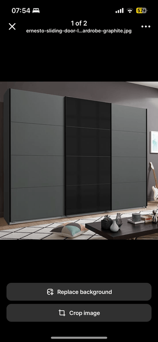 The CHOICEWARDROBE Ernesto 3 Door Sliding Wardrobe in matt graphite and black glass finish (270cm) is placed along a wall in a modern room with MDF furniture, a rug, coffee table, and décor accents.