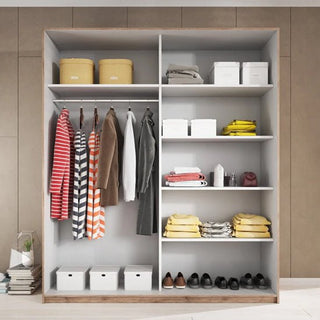The CHOICEWARDROBE Gitega 200cm 2 Door Sliding Wardrobe in matt white & oak finish features shelves, a hanging rail for clothes, and organized space for boxes, baskets, and shoes. Beige walls and a stack of magazines complete the setting.