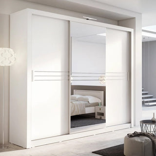 The CHOICEWARDROBE Hanover 3 Door Sliding Mirrored Wardrobe in 250cm matt white with LED light and storage shelves adds a sleek, modern touch to UK bedrooms, reflecting the room's furnishings for a stylish and spacious feel.