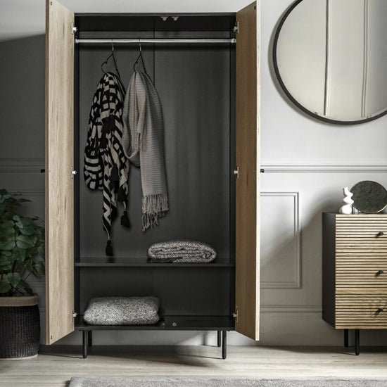 CHOICEWARDROBE Helena 2 door natural oak ribbed wardrobe open showing hanging scarves and folded blankets.