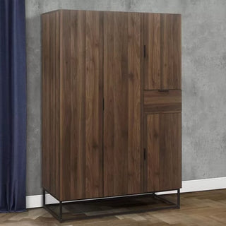 The CHOICEWARDROBE Huston 4 Door Wooden Wardrobe in walnut finish features an industrial metal frame and modern storage, shown against a gray wall with a dark blue curtain.
