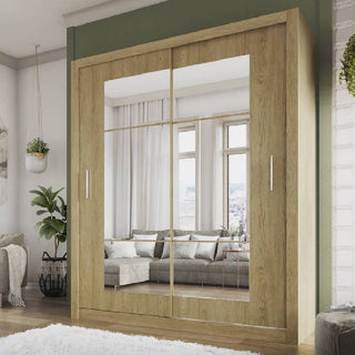The CHOICEWARDROBE Ionia 180cm Oak Mirrored Sliding Door Wardrobe, featuring modern wooden design with hanging rails and shelves, reflects a living room with a sofa, cushions, windows, and a hanging plant.