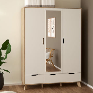 The CHOICEWARDROBE Irvine Oak & White 3 Door Mirrored Wardrobe, featuring a Scandinavian mid-century design and two drawers, stands with its mirrored door reflecting a wicker chair, framed art, and a green plant against a tan wall.