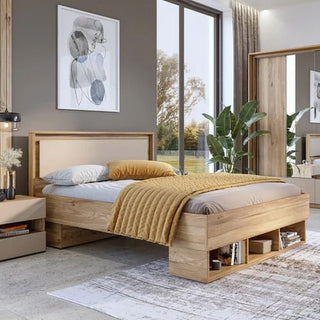 A modern bedroom features a wooden bed frame, beige and yellow bedding, a nightstand with lamp, large window, carpet, art above the bed, and the CHOICEWARDROBE Irving Mirrored Sliding Wardrobe in Mauvella Oak for stylish storage.
