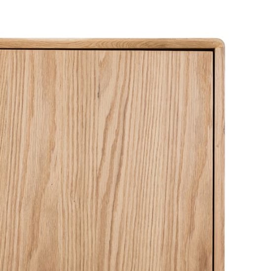 Close-up of light oak effect wooden wardrobe surface showing natural grain detail and clean edge.
