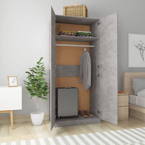CHOICEWARDROBE Kaylor 2 door wardrobe in concrete effect, with folded clothes, hanging shirt, suitcase, and shoes.