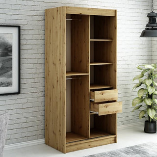 The CHOICEWARDROBE Laconia Mirrored Wardrobe, featuring 2 sliding doors in black and oak with a full-length mirror and smooth glide tracks, adds modern style and space-saving storage against a white brick wall.