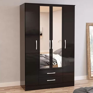 The CHOICEWARDROBE Lynn 4 Door Mirrored Wardrobe with 2 Drawers in black high gloss stands against a beige wall on a wooden floor, with a bed and framed mirror partially visible nearby.