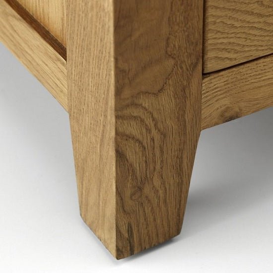 Close-up of a solid oak wardrobe leg with a waxed finish and visible wood grain.