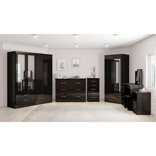 A modern bedroom features the CHOICEWARDROBE Mack 2 Door Wardrobe with Mirror & 1 Drawer in a black finish. Light walls, framed pictures, and large windows brighten and organize the space along with dressers and a desk.