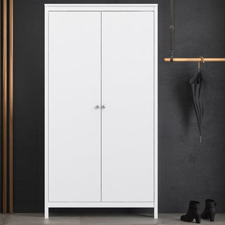 The CHOICEWARDROBE Macron 2 Door Wooden Wardrobe in Matt White stands against a dark gray wall. To the right, a black umbrella hangs from a wooden rod, with black boots neatly placed below.