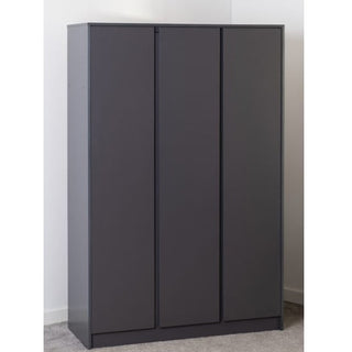The CHOICEWARDROBE Mcgowen 3 Door Wooden Wardrobe in grey (115cm) with a flat top and handleless, modern design stands against a white wall on grey carpet, offering spacious hanging and shelving storage.