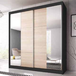 The CHOICEWARDROBE Mesa 2 Door Sliding Mirrored Wardrobe (233cm, black frame, oak panels) adds modern luxury to a bright room, with full-length mirrors reflecting décor and enhancing contemporary style.