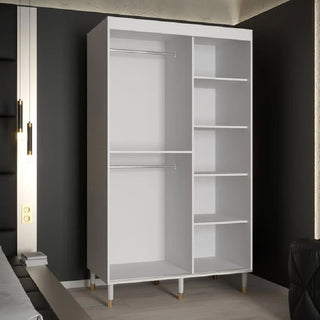 The CHOICEWARDROBE Millwall 120cm White Mirrored Sliding Door Wardrobe, featuring a fluted panel design, gold handles, and modern storage shelves, adds sleek bedroom storage against a dark wall in this contemporary space.