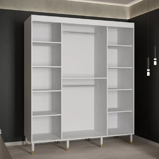The CHOICEWARDROBE Millwall 180cm White Sliding 2 Door Wardrobe features ribbed panels, gold handles, and an elegant modern design—ideal for stylish bedroom storage in rooms with dark walls and wooden flooring.