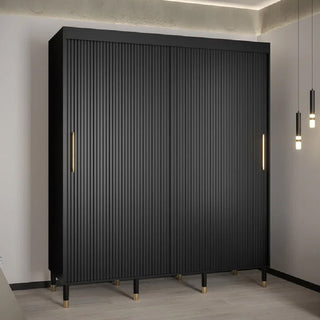The CHOICEWARDROBE Millwall 2 Door Sliding Wardrobe (180cm, matt black) features a ribbed design, gold handles, and raised metal legs. Positioned by a white wall with pendant lights and ceiling LEDs, it delivers stylish bedroom storage.