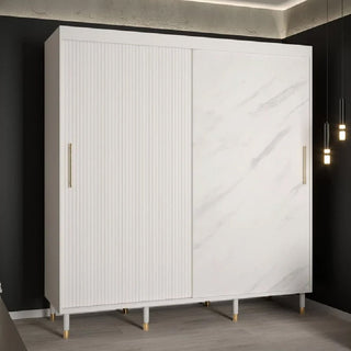 The CHOICEWARDROBE Millwall 200cm White Marble Effect Sliding Wardrobe features ribbed and smooth marble-like doors, gold handles, and an elegant modern finish, standing out stylishly against a dark wall with nearby pendant lighting.