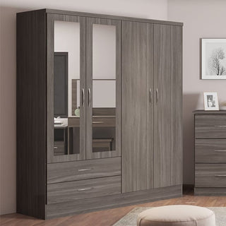 The CHOICEWARDROBE Modara Black Wood Grain 4 Door Mirrored Wardrobe with drawers and a hanging rail stands next to a matching dresser in a bedroom with light walls and framed artwork.