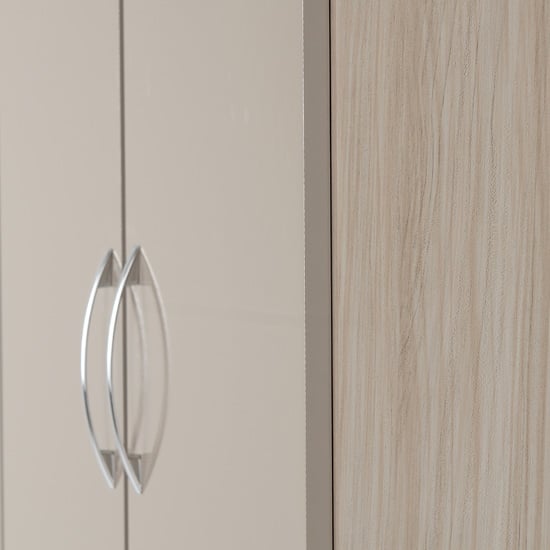 Two brushed metal oval handles on taupe gloss wardrobe door with oak wood panel detail.