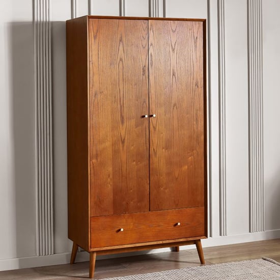 Mid-century modern cherry wood wardrobe with two doors and a drawer, featuring tapered legs.