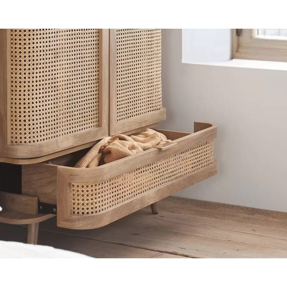 Oak rattan wardrobe with cane detail: open drawer revealing knit blanket. Boho Scandi style.