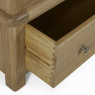 A close-up of a partially open drawer with dovetail joints and metal knob, part of the CHOICEWARDROBE Norland Limed Oak 2 Door Wardrobe—classic wooden farmhouse style with a natural finish.
