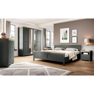 A modern bedroom with gray furniture—a bed, nightstand, dresser—and the CHOICEWARDROBE Norrin Deep Green & Oak Mirrored 3-Door Wardrobe. Wood floors, large windows, neutral walls, framed art, and a table lamp on the nightstand complete the space.