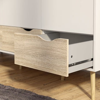 The CHOICEWARDROBE Oklo 3 Door Wardrobe in white and oak finish features three drawers with cut-out handles, modern legs, and a Scandinavian design—ideal for bedroom storage and stylishly complementing wood floors and gray rugs.