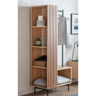 The CHOICEWARDROBE Okonma Wooden Open Wardrobe, featuring a natural oak slatted design with shelves and a hanging rail, stands beside a coat rack with striped clothing in a modern room.