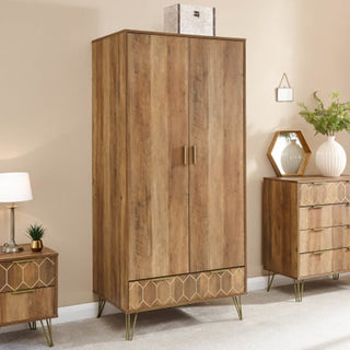 Rustic oak 2 door wooden wardrobe with gold geometric detailing and retro legs, styled with matching bedroom furniture for a warm modern look.