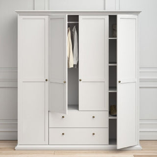 The CHOICEWARDROBE Paroya 4 Door 2 Drawer Wardrobe in White (181cm) features hanging rails, shelves, and two large drawers—offering modern wooden bedroom storage against a paneled wall and wooden floor.