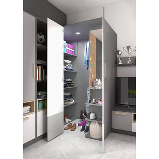 The CHOICEWARDROBE Pearl Kids Corner Wardrobe in two-tone grey & white features a compact walk-in design with open shelves for clothes, shoes, bags, and boxes. Adjacent cabinets and a TV unit displaying trophies and books are also visible.
