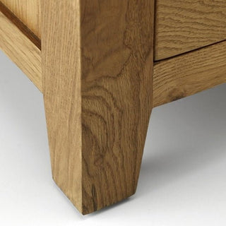 Close-up of the corner leg and lower side panel of the CHOICEWARDROBE Porsha 142cm 3 Door Waxed Oak Wardrobe, highlighting its light solid oak frame, wood grain, joinery, and classic Shaker design with a waxed finish.