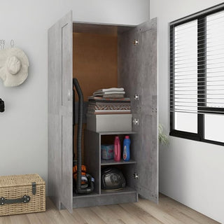 The CHOICEWARDROBE Portland 2 Door Wardrobe – Concrete Effect Finish with Shelving stands open in a bright room, displaying neatly organized cleaning supplies, an iron, folded towels, and a vacuum cleaner.