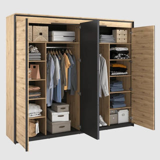 The CHOICEWARDROBE Qesso 4 Door Hinged Mirrored Wardrobe in rustic oak with LED light and black frame opens to reveal neatly organized shelves, hanging clothes, folded garments, storage boxes, and baskets.