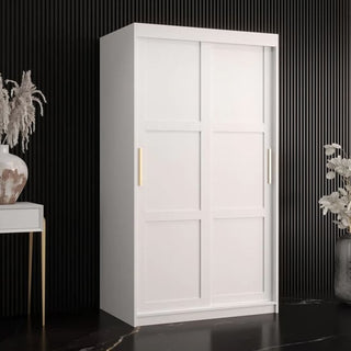 The CHOICEWARDROBE Rieti I 2 Door Sliding Wooden Wardrobe in white with gold handles and internal storage shelves stands against a black, vertically grooved wall, accented by decorative vases with dried plants.