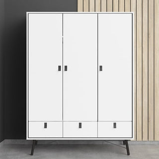 The CHOICEWARDROBE Rynok 150cm 3 Door Wooden Wardrobe in matt white with modern metal legs, drawers, and hanging storage stands beside a black wall on the left and vertical light wood panels on the right.