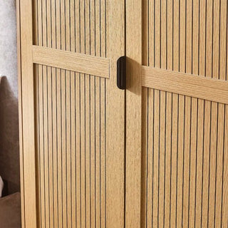 A close-up of the CHOICEWARDROBE Sarnia Natural Oak 2 Door Wardrobe, featuring slatted wood doors, a central black handle, and metal legs in a Japandi modern design against a neutral background.