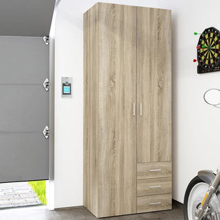A CHOICEWARDROBE Scalia 2 Door 3 Drawer Wardrobe in modern oak finish (77cm wide) stands against a white garage wall, near a dartboard, with part of a parked motorcycle visible in the foreground.