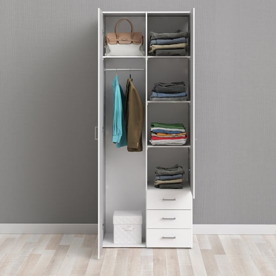 Open white wardrobe interior with hanging rail, shelves and three storage drawers.