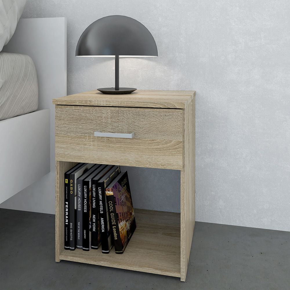CHOICEWARDROBE Scalia Oak Bedside Table: Natural Oak finish, drawer, shelf with books & black lamp.