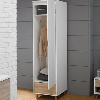The CHOICEWARDROBE Selkirk 50cm Wooden Single Door Wardrobe in white & oak finish stands against a gray paneled wall, with its door partly open to show a hanging beige shirt, two folded gray blankets on a shelf, and a closed bottom drawer.