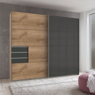 The CHOICEWARDROBE Sogo 2 Door Sliding Wardrobe (225 cm) features an oak and black two-tone finish, modern design, sliding doors, three drawers on the left, shelves, and hanging rails—ideal for a bright, minimalistic room.
