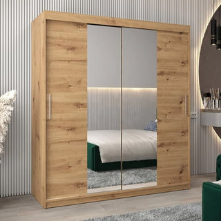 The CHOICEWARDROBE Tavira 2 Door Mirrored Sliding Wardrobe (180 cm, Artisan Oak Finish) with shelves and hanging rails adds stylish storage to a modern bedroom with a striped wall, bed, rug, and circular mirror on the vanity.