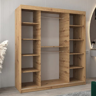 The CHOICEWARDROBE Tavira 2 Door Mirrored Sliding Wardrobe (180 cm, Artisan Oak Finish) features shelves and hanging rails for practical bedroom storage, complementing a light-colored, vertically-striped wall with its modern design.