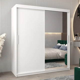 The CHOICEWARDROBE Tavira 2 Door Mirrored Sliding Wardrobe (180cm, white) adds modern style and space-saving storage to a sleek bedroom, with one full mirror door reflecting the striped wall, bed, rug, and vanity.