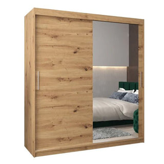 The CHOICEWARDROBE Tavira 2 Door Oak Effect Sliding Wardrobe (180cm) features one solid artisan oak panel and one large mirrored door, shelves, a hanging rail, and two sleek metal handles for a modern bedroom look.